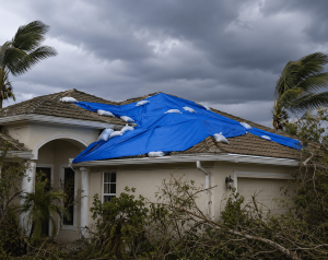 One Story House With Blue Roof Tarp